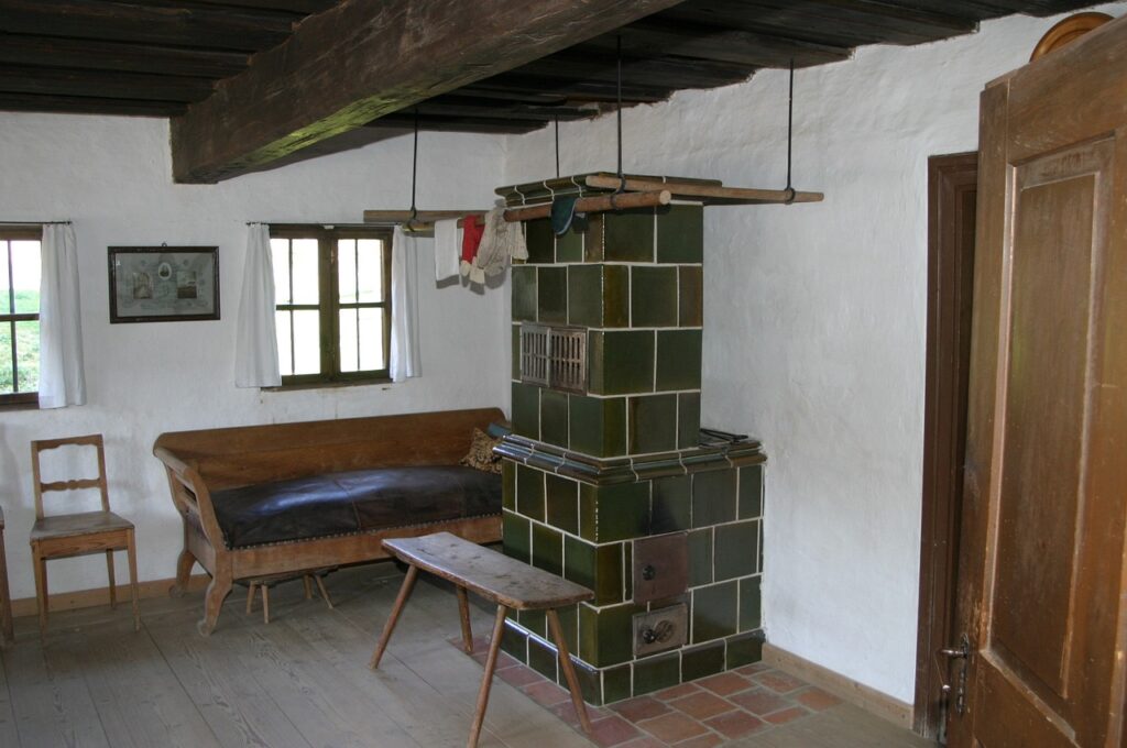 Ein traditioneller Kachelofen in einer gemütlichen Stube, der für eine warme und heimelige Atmosphäre sorgt.