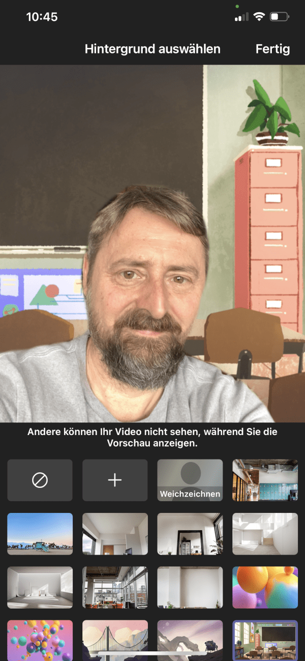 Screenshot der Microsoft Teams App, der die Auswahl von Hintergründen während eines Videoanrufs zeigt. In der Video-Vorschau ist ein benutzerdefinierter Hintergrund platziert, und eine Person ist im Bild zu sehen.